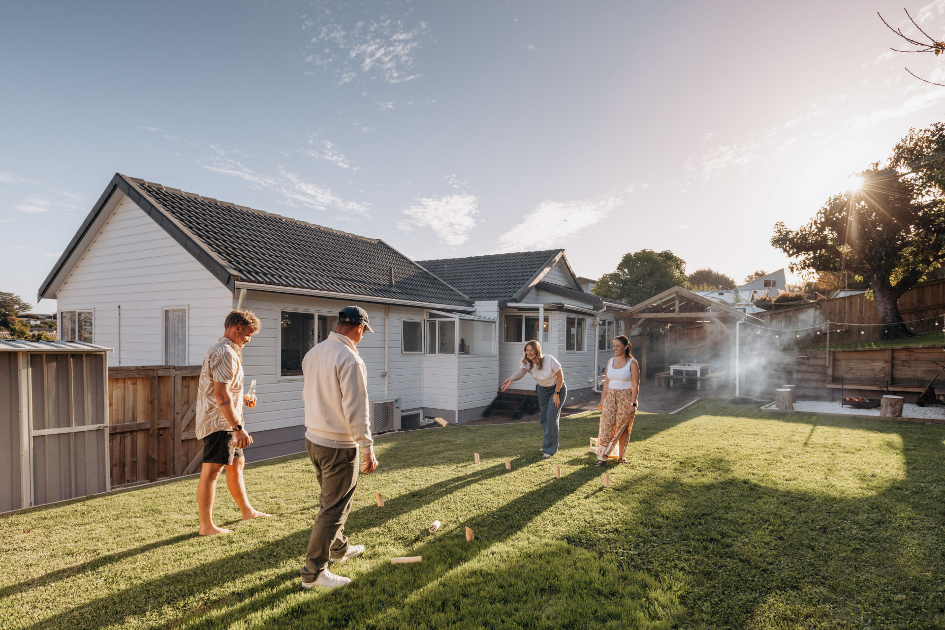 Friends playing lawn games in a sunny Mount Maunganui backyard